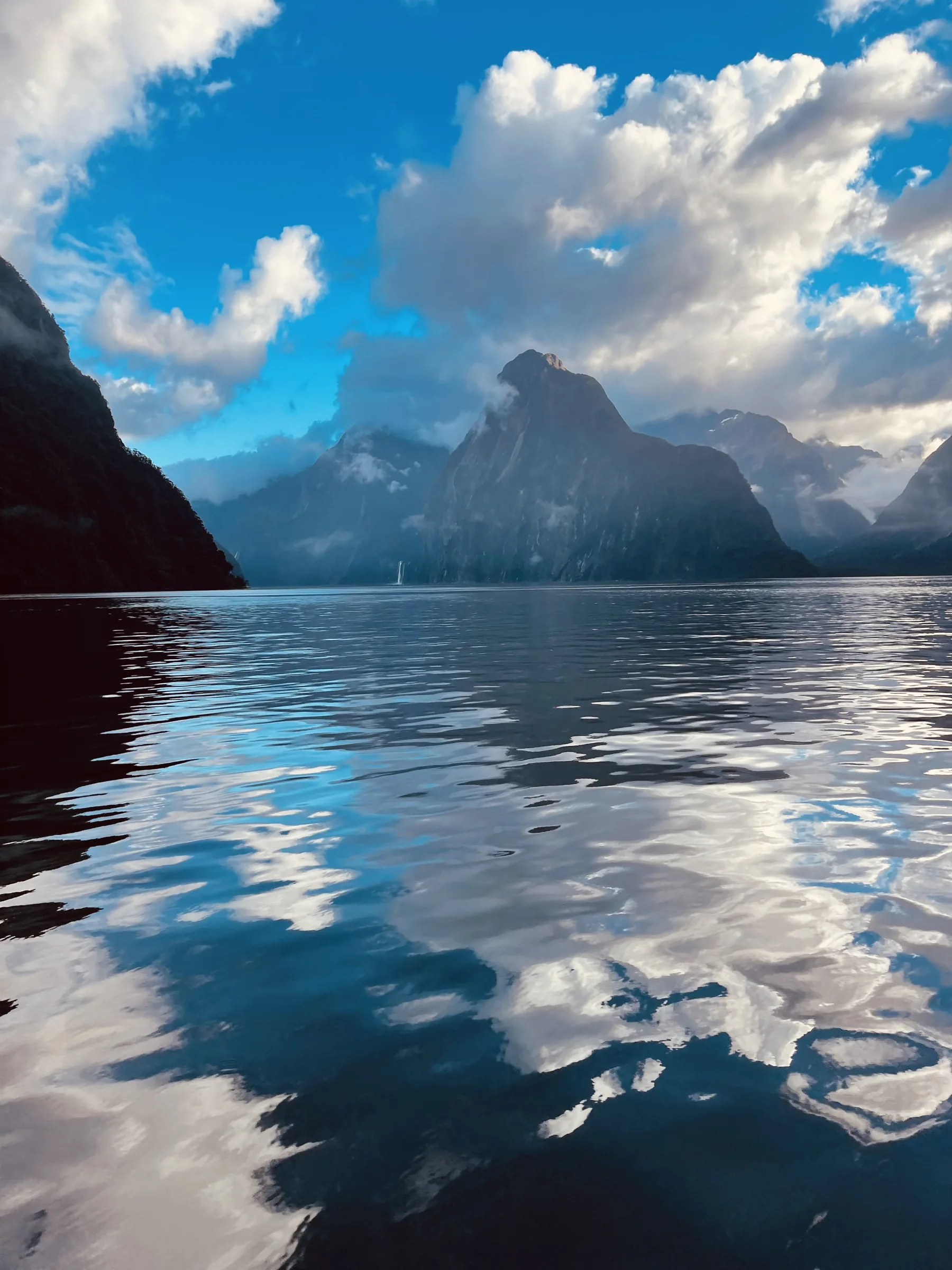 Berge und Wolken spiegeln sich im stillen Wasser von Fiordland.